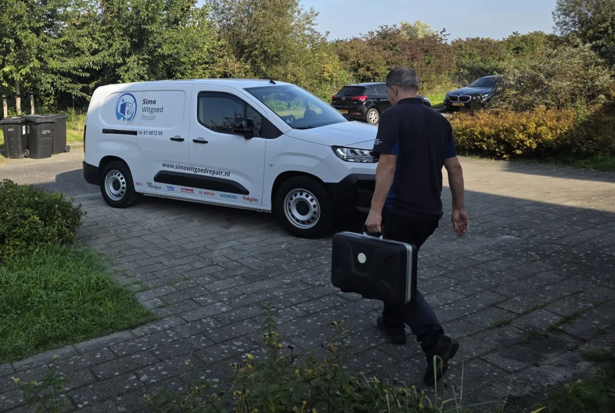 De monteur loopt met zijn gereedschapskoffer van de witte bus van Simo Witgoed Repair naar de klant
